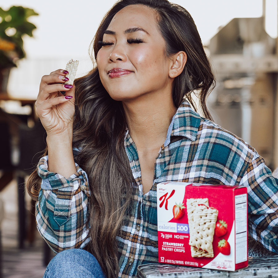 A smiling woman enjoying a Special-K breakfast bar.
